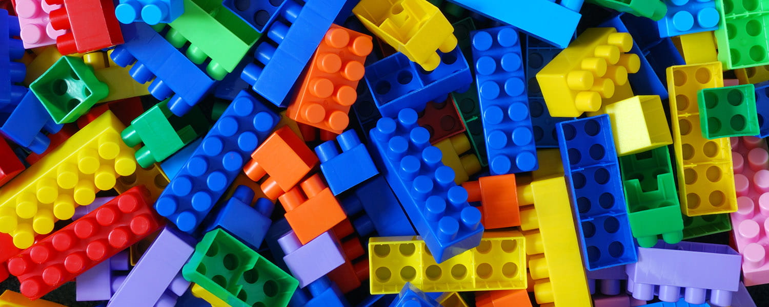 Pile of various colored children's building blocks.