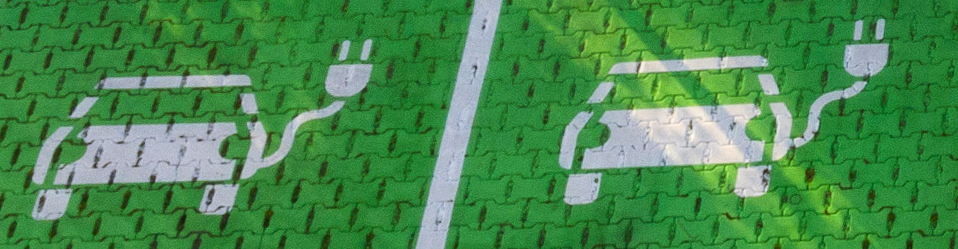 Painted symbol of a white electric vehicle on pavement.