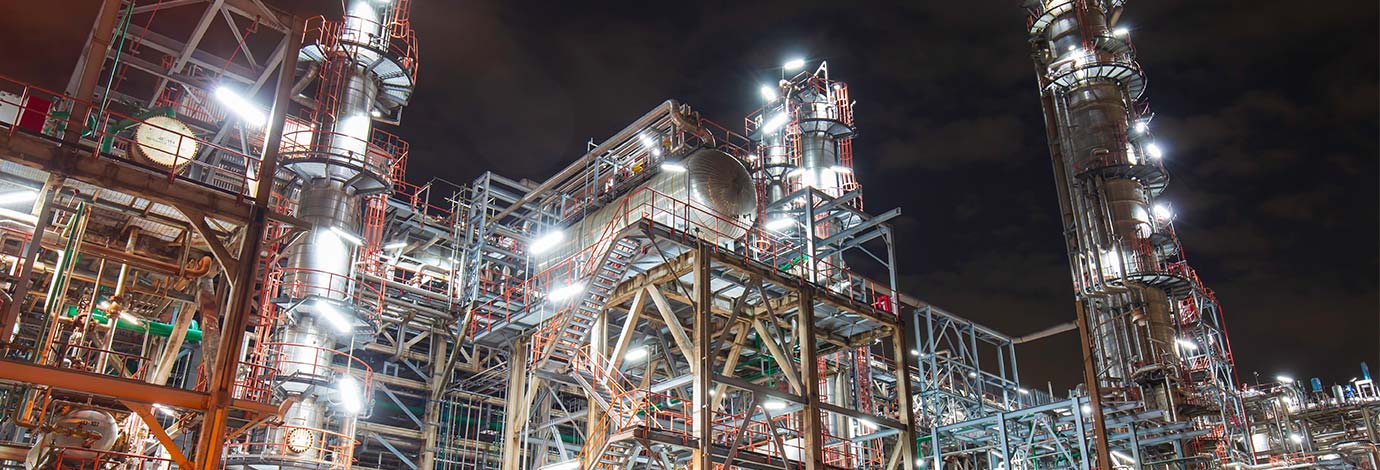 Oil​ and gas refinery at night illuminated with lights​.