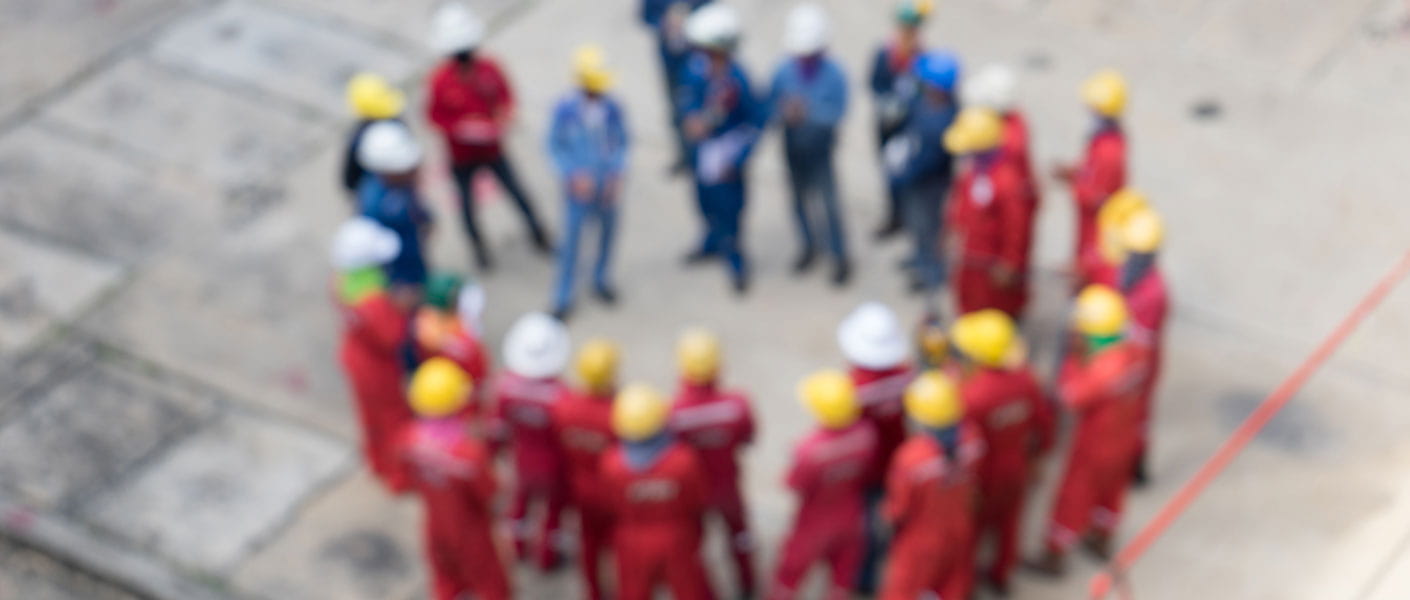 Workers standing in a circle in PPE gear